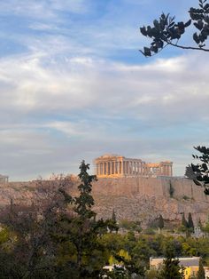 the parthenon and parthen hill in the distance, with trees on either side