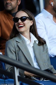 a woman wearing sunglasses is sitting in the stands