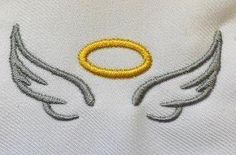 an embroidered shirt with wings and a gold ring on it