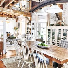 the dining room table is surrounded by white chairs and wooden tables with plants on them