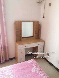 a bedroom with a dresser and mirror next to a pink bed spread on the floor