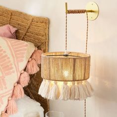 a lamp that is hanging from a wall next to a bed