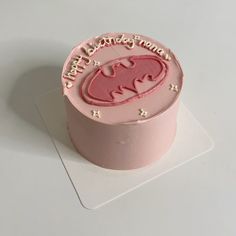 a pink birthday cake with the name batman on it