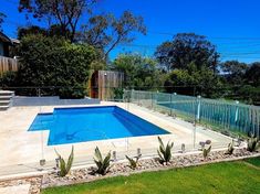 an empty swimming pool in the middle of a yard with fenced in areas around it