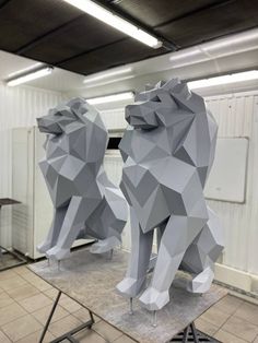 two sculptures of bears sitting on top of each other in the middle of a room