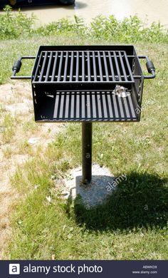 an outdoor bbq grill in the middle of a grassy area