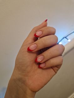 Red French Tips With Candy Cane Ring Finger, Red Tip Nails With Pearls, Red French Tip With Silver Line, Red And White French Tip Nails Christmas, Red French Tips With Snowflakes, Red French Tips Christmas, Almond Shaped Nails Christmas, Christmas Nails French Tip Red, Red French Tip With Snowflake