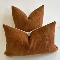 two brown pillows sitting on top of a white table