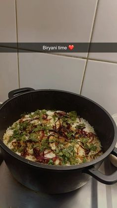 a pan filled with food sitting on top of a stove next to a tiled wall