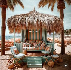 a beach scene with palm trees, chairs and a couch under a thatched umbrella