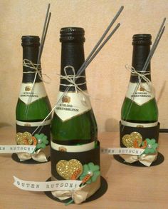 three bottles of champagne are sitting on a table with ribbon around them and tags in the shape of shamrocks