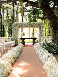 an image of a wedding ceremony with white flowers and greenery on the side walk