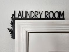 there is a sign that says laundry room hanging on the wall next to a door