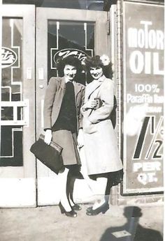 two women are standing in front of a store