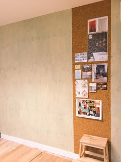 a cork board wall with pictures on it and a wooden bench in the corner next to it