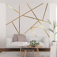 a living room with white furniture and gold lines on the wall