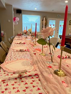 a long table with pink and red hearts on it is set up for a valentine's day party