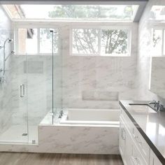 a bathroom with a tub, sink and shower in it's own area is shown