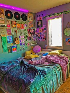 a bedroom with purple walls and lots of pictures on the wall above the bed,