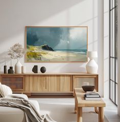 a living room filled with furniture and a painting hanging on the wall over a coffee table