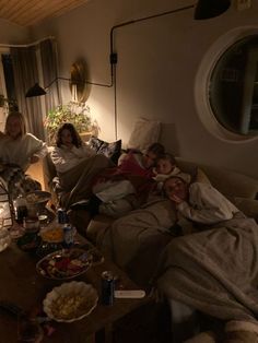 a group of people sitting on top of a couch in a living room next to a window