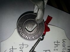 a silver medal with a red ribbon around it on top of a piece of paper