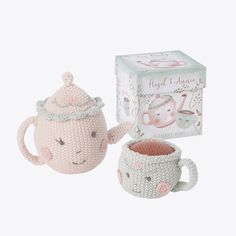 a crocheted teapot and cup in front of a box