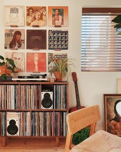 an old record player is sitting in front of a wall full of records and posters