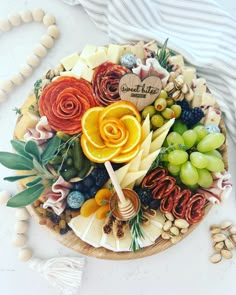 a platter filled with fruit and cheese