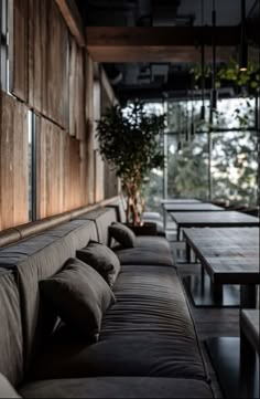 the couches and tables are lined up against the wooden wall in this restaurant setting