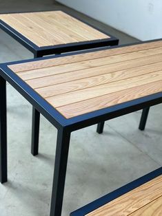 two wooden tables with metal legs on concrete floor