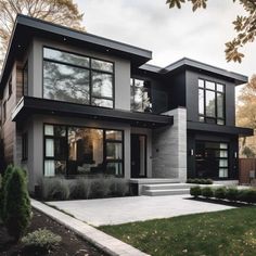 a large modern house with lots of windows on the front and side of the house