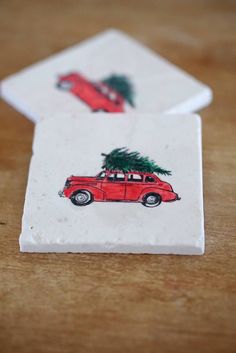 two coasters decorated with red cars and a christmas tree on the top one is white