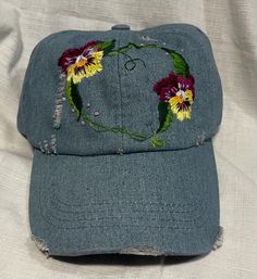 This floral heart garland is hand embroidered on a 100% cotton distressed baseball cap . One size fits all, with Velcro adjustable back . Spring Cotton Dad Hat Baseball Cap, Spring Cotton Baseball Cap With Embroidered Logo, Spring Cotton Dad Hat, Spring Distressed Adjustable Baseball Cap, Cotton Dad Hat For Spring, Spring Cotton Snapback Dad Hat, Spring Snapback Dad Hat In Cotton, Casual Curved Brim Baseball Cap For Festivals, Distressed Adjustable Baseball Cap For Spring