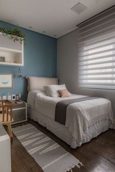 a bedroom with blue walls and wooden floors