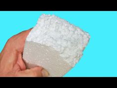 a hand holding a sponge over a blue background