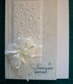 a white greeting card with a bow on the front and back of it that says someone special