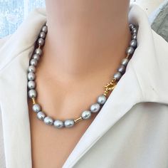 This gray pearl necklace is a unique soft and feminine piece of jewelry. The necklace typically consists of gray freshwater pearls that are strung together with a Gold Vermeil plated silver marine clasp and beads, allowing you to hold or not any of your pendant. A statement piece that can be worn for various occasions, from casual to formal. Ideal gift on Valentine's day or mother's day, or simply her birthday. Hand-knotted the traditional way on a white thread.  MATERIALS Freshwater grey pearls Grey Pearls Jewelry, Luxury Gray Pearl Necklace Gift, Pearl Necklace With Gold, Grey Pearl Necklace, Pearl Necklaces, Necklaces For Women, Pearl Grey, Best Gift, Pearl Jewelry