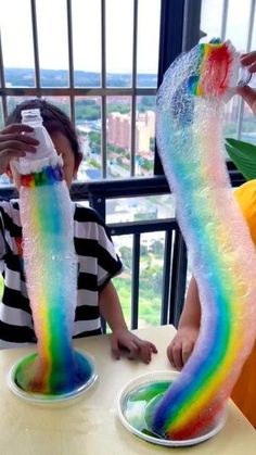 two children are sitting at a table with fake rainbow socks