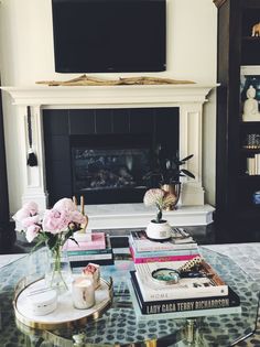 a living room filled with furniture and a flat screen tv mounted above a fire place