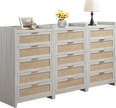 a white dresser with several drawers and a lamp