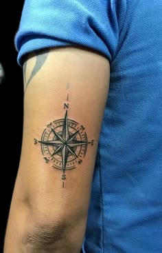 a man with a compass tattoo on his arm