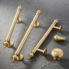 four brass handles and knobs on a gray surface