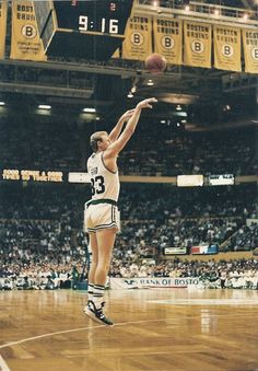 a basketball player is jumping up to dunk the ball in front of an audience