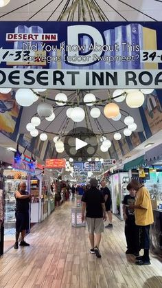 people are walking through an indoor shopping mall with signs above them that read desert inn road