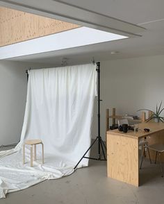 a photo studio with white backdrop and chairs