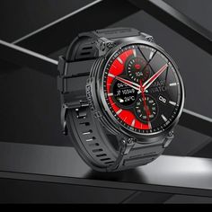 a black watch with red accents on the face and bracelets is shown in front of a dark background