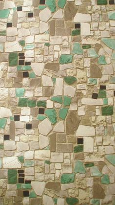 a close up view of a tile wall with green and white tiles on the side