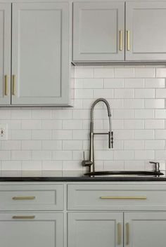 a kitchen with white cabinets and a gold chandelier