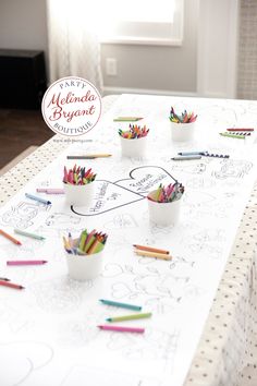 the table is covered with crayons and cups filled with colored pencils on it